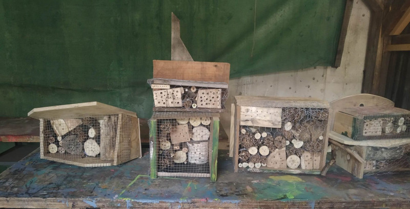 text: >
  Vier verschiedene Insektenhotels gebaut
  von Kindern. Es sind jeweils
  Holzkästen, die mit kleinholz gefüllt
  sind, in das kleine Löcher gebohrt
  wurden.
decorative: false
source: manual