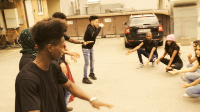 Tanzworkshop in einer Garage mit mehreren Teilnehmenden, die gemeinsam an einer Choreografie arbeiten