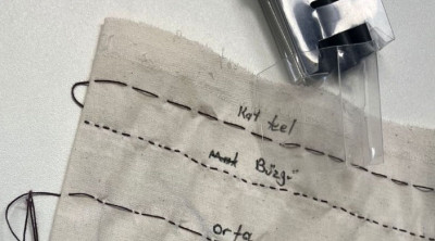 Stoffstück mit Nählinien und handschriftlichen Markierungen für ein Nähprojekt