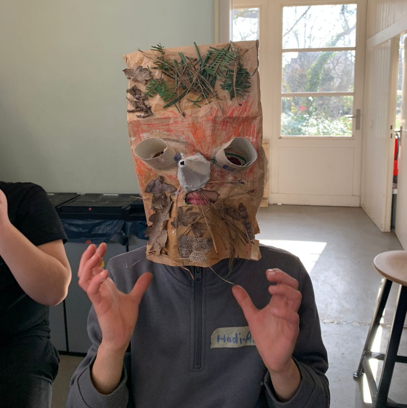 text: >
  Kind trägt eine selbstgebastelte Maske
  aus Papiertüte mit aufgemaltem Gesicht
  und natürlichen Materialien wie Ästen
  und Blättern
decorative: false
source: reviewed