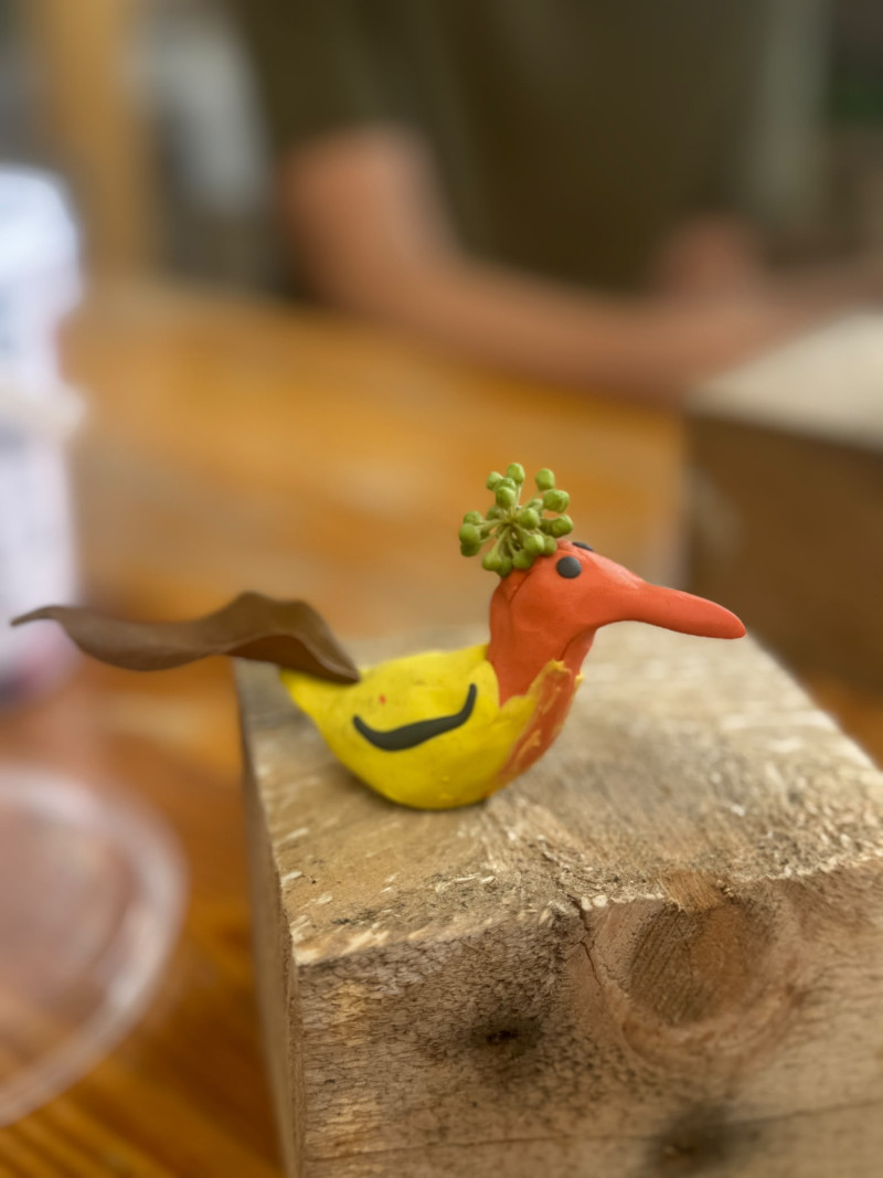 text: >
  Handbemalte Vogelfigur aus Knete mit
  gelbem Körper, orangerotem Kopf und
  grünen Blättern als Haartracht
decorative: false
source: reviewed