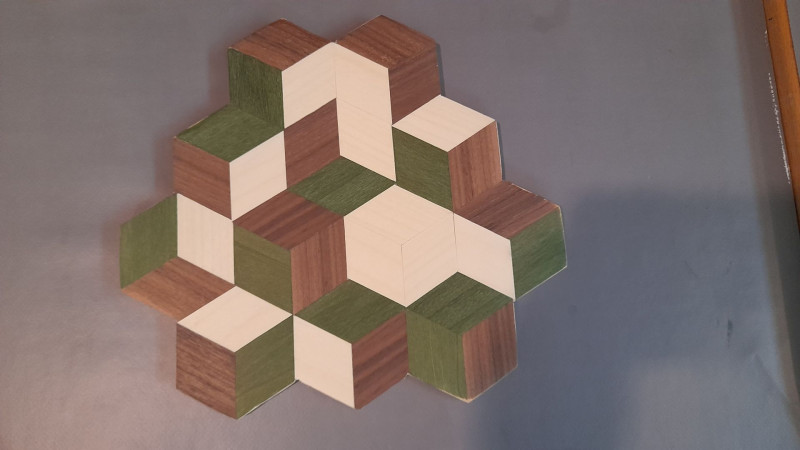 text: >
  Geometrisches Muster in 3D Optik aus
  verschiedenen kleinen Holz-Quadraten in
  verschiedenen Farben.
decorative: false
source: manual