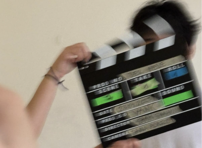 Eine Hand, die eine Filmklappe hält