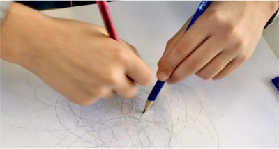 Kind malt mit Stift auf Papier während eines Kunstprojekts