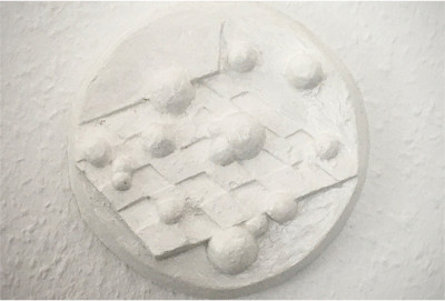 Relief-Skulptur mit geometrischen Formen und runden Elementen in weißem Gips