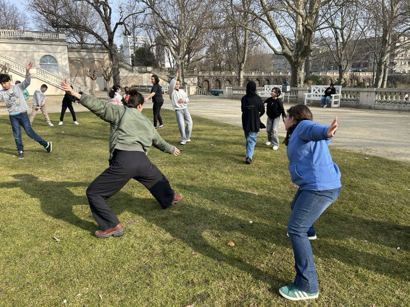 text: >
  Eine Gruppe von Kindern und Jugendlichen
  bewegt sich spielerisch auf einer Wiese
  im Körnerpark. Im Hintergrund sind eine
  große Freitreppe, Bäume und
  Parkanlagen zu sehen. Die Gruppe macht
  verschiedene Bewegungen mit
  ausgestreckten Armen.
decorative: false
source: manual
