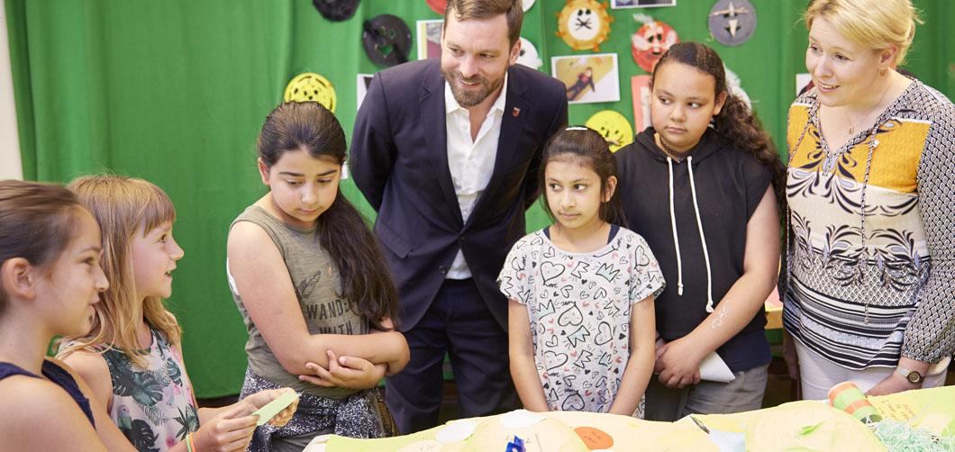 Schüler*innen führen Bezirksbürgermeisterin Giffey und Stadtrat Rämer durch die Ausstellung. 